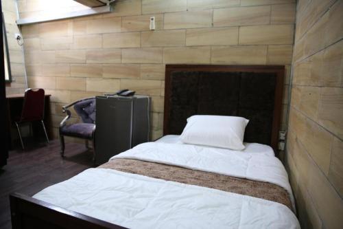 拉各斯HPLagos BT的一间卧室配有一张大床和椅子