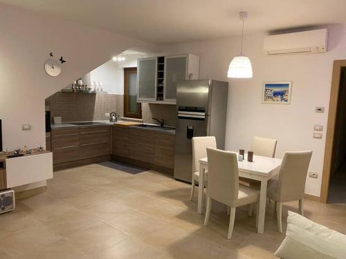 雷卡纳蒂港Appartamento al mare - Porto Recanati的厨房配有桌椅和冰箱。