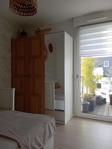 斯特拉斯堡Chambre nature chez l'habitant的一间卧室设有一张床和一个滑动玻璃门