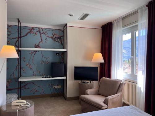 加尔达湖滨Villa Miravalle的酒店客房设有椅子和电视。