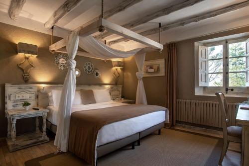 贝里奥帕拉诺Hotel Luze El Toro的一间卧室配有一张天蓬床和一张桌子
