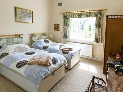 Saint LawrenceWestgate Cottage的一间卧室设有两张单人床和一个窗户。