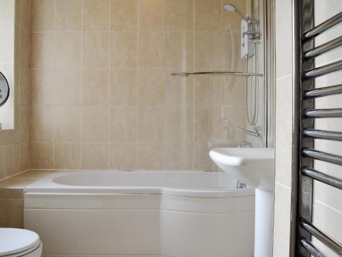 Saint LawrenceWestgate Cottage的带浴缸、卫生间和盥洗盆的浴室