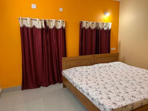 普里Shradharam Lodge的一间设有红色窗帘的卧室,内有一张床