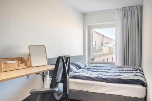 斯德哥尔摩Private room in Hammarby Sjöstad, common space shared!的一间卧室配有一张床、一张书桌和一个窗户。