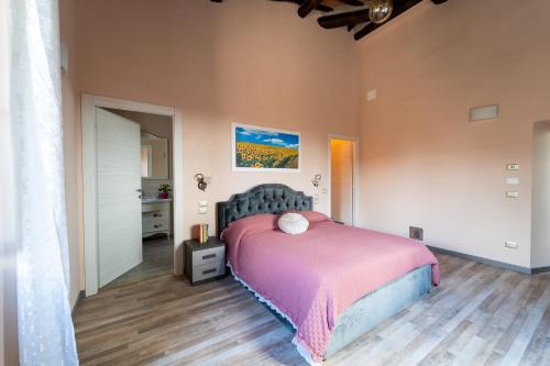 科尔托纳Casale Il Terranova的一间卧室配有一张带粉色毯子的床