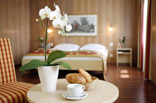 卢塞恩德拉帕斯酒店的配有一张带花卉和床的桌子的酒店客房