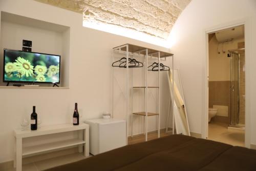 巴里Al Guiscardo 8的一间卧室配有一张床,墙上配有电视
