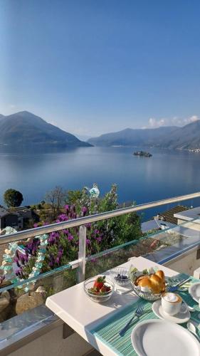 阿斯科纳Sollevante Ascona的俯瞰湖泊的阳台上一张带盘子的桌子
