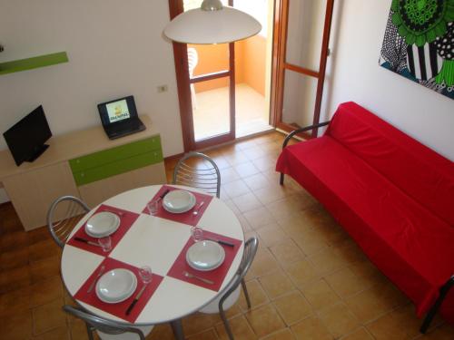 丽都阿德里亚诺奥罗拉住宅酒店的客厅配有桌子和红色沙发