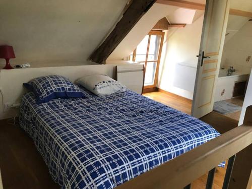 蒙特多尔Maisonnette au pied du Mont Dol的卧室配有蓝色和白色的床,设有窗户
