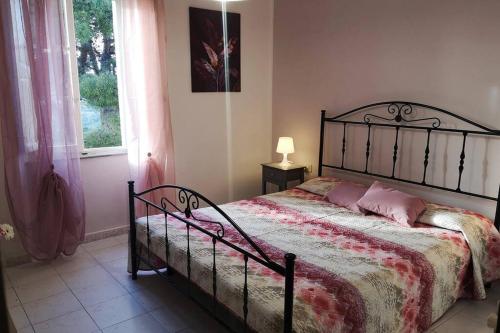 卡波利韦里La casa dei nonni的一间卧室配有带粉红色枕头的床和窗户。