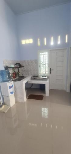 HalanganHOMESTAY PANDAN的一间白色的厨房,配有桌子和门