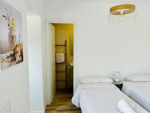 滨海比拉萨尔Vilamarlux VII的白色墙壁客房的两张床
