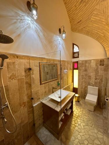 布哈拉Marhaba boutique Madrasah 15th-16th century的一间带水槽、淋浴和卫生间的浴室