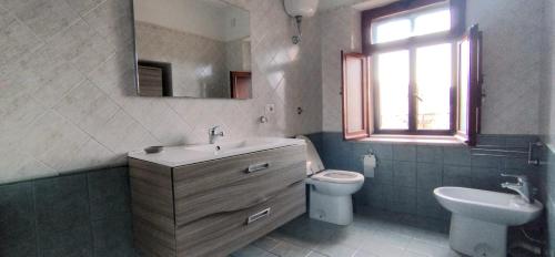 莫拉诺卡拉布罗Pollino House的一间带水槽和卫生间的浴室以及窗户。