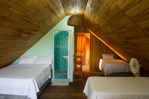 布兰卡滩Hotel Calamari Baru的阁楼卧室配有两张床和镜子