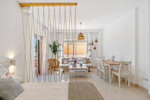 托雷德本纳贾尔邦Niña Sureña Home Añoreta Golf的客厅和配有一张床铺和一张桌子的饭厅