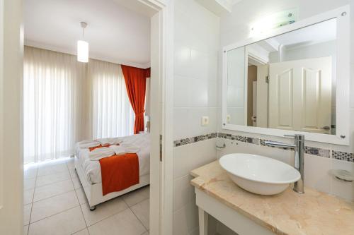 费特希耶Yaşam Park Rena Villaları Ölüdeniz的白色的浴室设有水槽和一张床