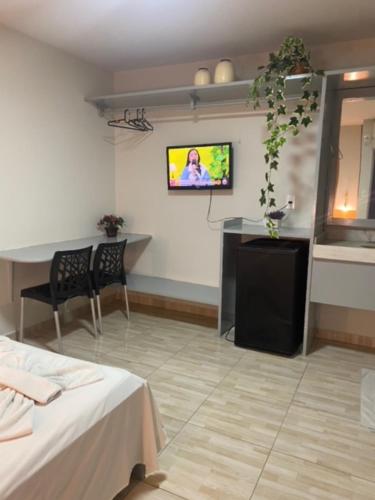 卡鲁阿鲁维塔利诺大师旅馆的一间设有桌子的房间和墙上的电视