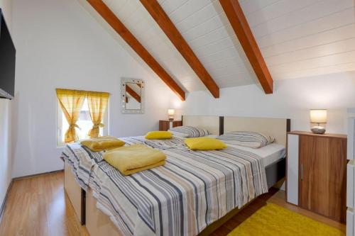 Mursko SredišćeKuća za odmor Hren的一间卧室配有一张带黄色枕头的大床