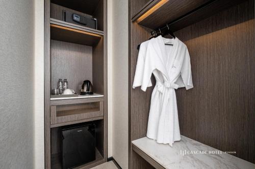 曼谷Cascade Hotel Bangkok的浴室墙上挂着白色的长袍
