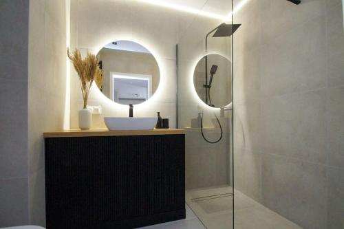 卡托维兹Apartament, Ceglana 76, Katowice的浴室配有盥洗盆和带镜子的淋浴