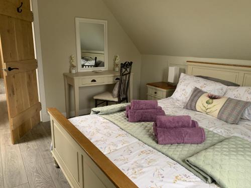 阿博因Birchwood View的一间卧室配有一张带紫色枕头的床和一张书桌