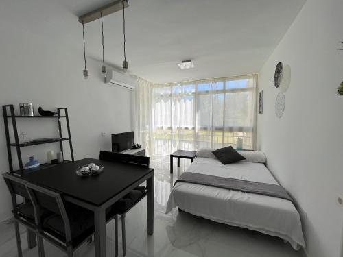 卡拉德莫尔Apartamento con piscina y barbacoa的一间卧室配有一张床、一张书桌和一个窗户。