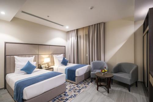阿可贺巴Enala Hotel - Al Khobar的酒店客房,配有两张床和椅子