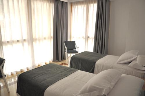 卡拉瓦卡·德·拉·克鲁斯NEO HOTEL的酒店客房,配有两张床和椅子