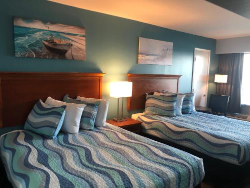 默特尔比奇Gazebo Inn Oceanfront的酒店客房设有两张床和两盏灯。