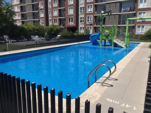 奇廉Departamento 3 Personas的一个带游乐场的大型蓝色游泳池