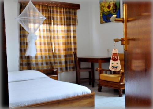 洛美奥罗尔洛美酒店的一间卧室配有两张床、一张桌子和一把椅子