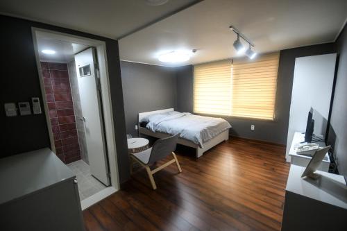仁川市Bluehum Guest house的卧室配有1张床、1张桌子和1把椅子