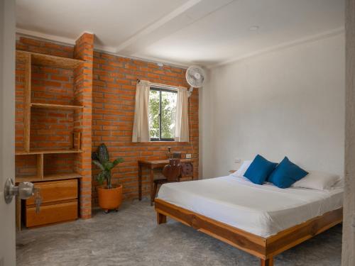 帕洛米诺Kallpa B&B的一间卧室设有一张床和砖墙