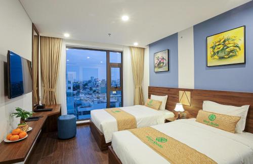 岘港Minh Quan Hotel - Da Nang Center By HOS的酒店客房设有两张床和大窗户。