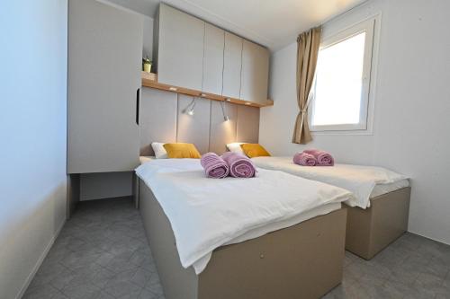 德拉格O'LIVE PREMIUM Mobile Home的配有白色和粉红色枕头的客房内的两张床