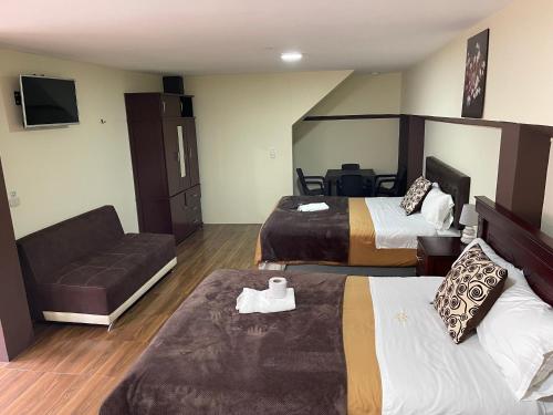 巴尼奥斯Hotel Casa Santa Lucía的酒店客房,设有两张床和一张沙发