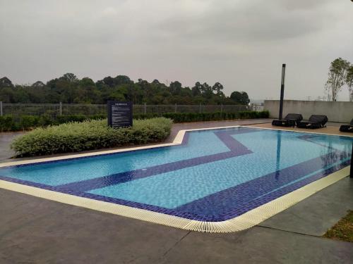 班吉Cozy Southville Bangi Free parking Wifi Netflix的旁边设有标志的大型游泳池