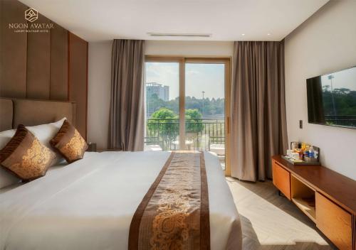 波来古市Ngon Avatar Hotel的一间卧室设有一张大床和一个大窗户