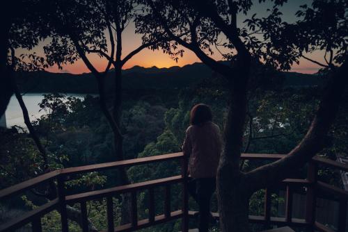 南伊豆町尤米加玛别墅度假屋的站在围栏上观看日落的女人