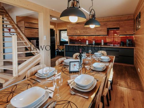 亚沃尔基Jaworki Prestige SPA的用餐室配有木桌、盘子和酒杯
