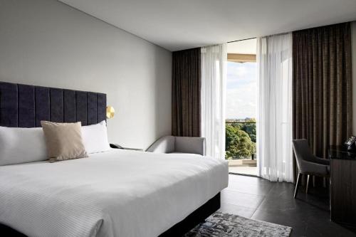 悉尼Crowne Plaza Sydney Burwood, an IHG Hotel的一间卧室设有一张大床和一个大窗户