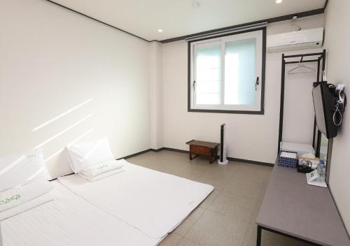 庆州卡萨迷你酒店的一间设有白色墙壁和窗户的客房
