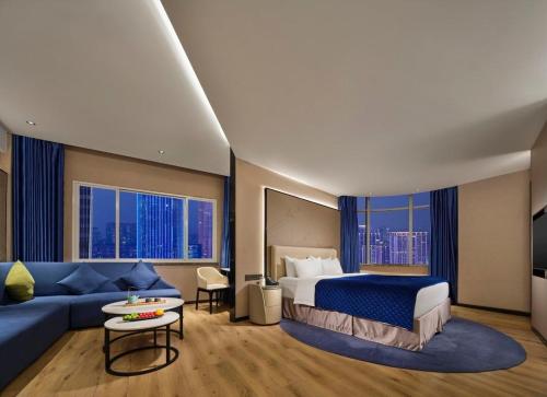 台州万斯酒店（台州店）的酒店客房,配有床和蓝色的沙发