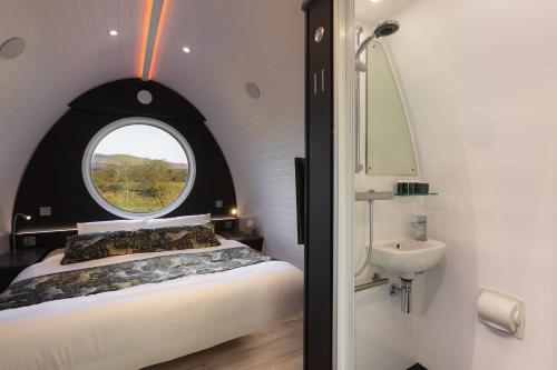 Endrick Escape - Luxury Glamping的一间卧室设有床、窗户和水槽