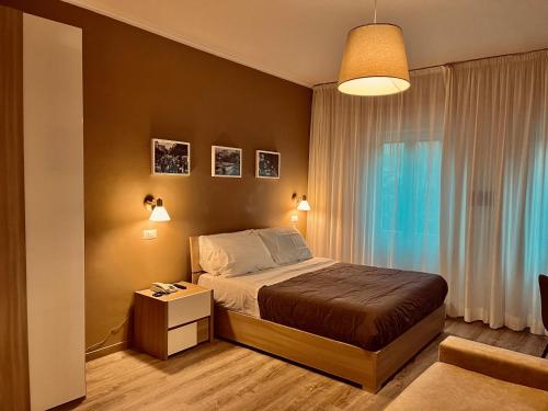 菲乌吉Albergo Ristorante Belsito的一间卧室配有一张床、一张桌子和一个窗户。