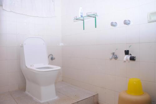 马迪凯里Misty Retreat (Pragati House)的白色的浴室设有卫生间和黄色凳子