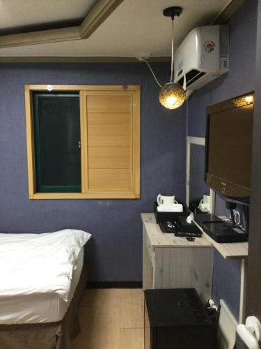首尔东大门G迷你酒店的客房设有一张床和一间带炉灶的厨房